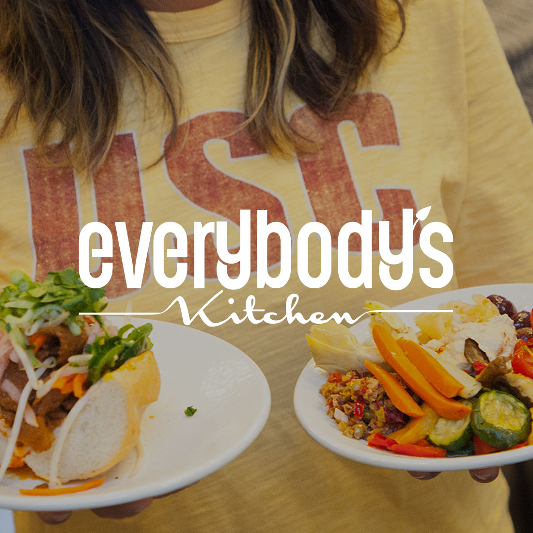 Student holding plates of delicious food