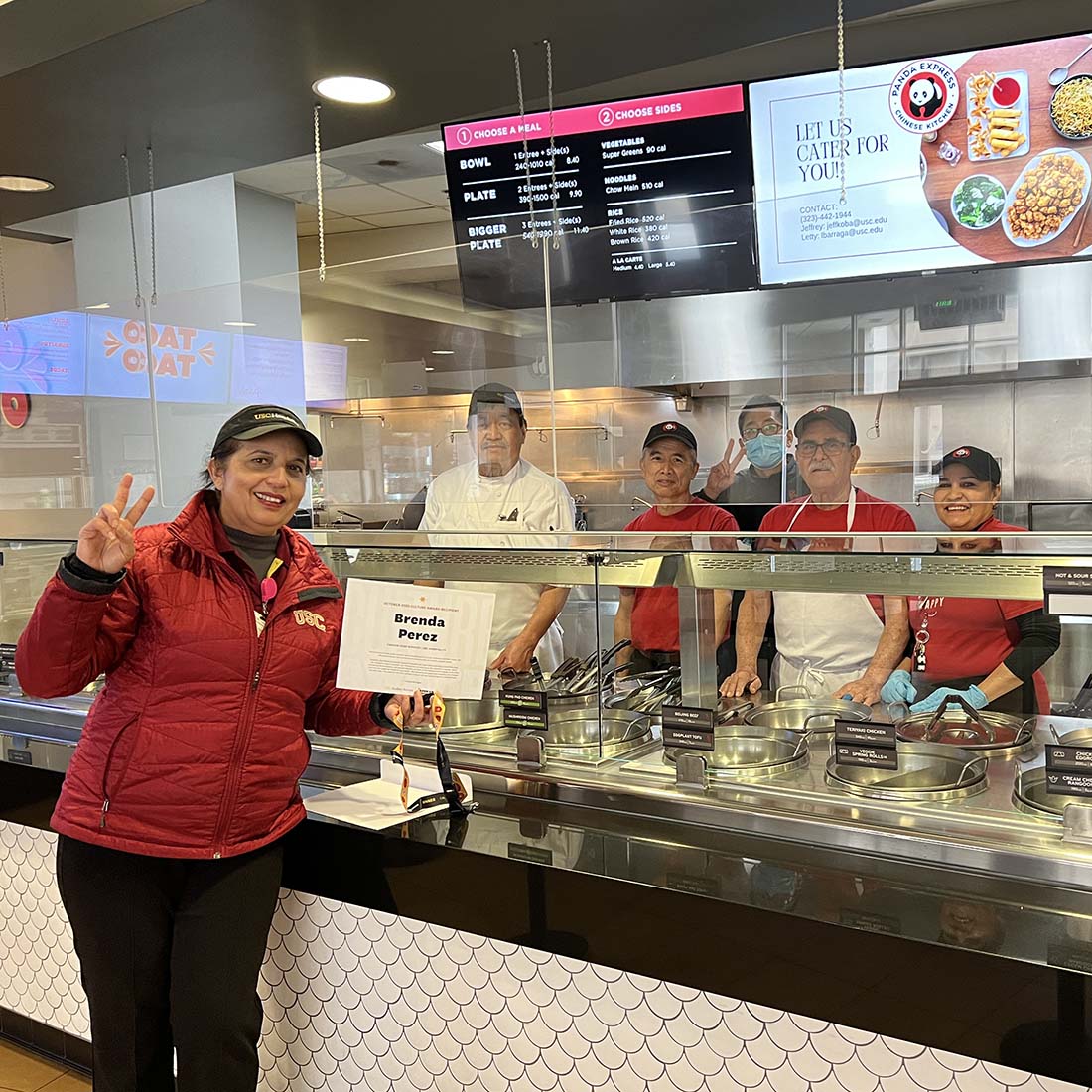 Employee giving the victory sign in front of a Panda Express counter